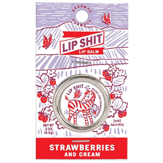 A Blue Q lip shit tin encased in purple cardboard packaging. The text reads: 'Lip shit lip balm Strawberries and cream' 