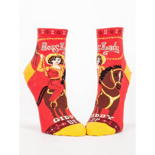 Red and yellow Blue Q socks featuring a girl riding a horse with a lasso. The text reads: Boss Lady - Giddy up