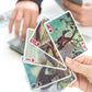 someone holding 4 different dinosaur lenticular playing cards.