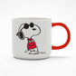 A white mug with a red handle. On the front of the mug there is a graphic of Snoopy with his arms crossed wearing a red jumper and black sunglasses. 