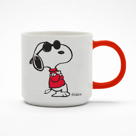 A white mug with a red handle. On the front of the mug there is a graphic of Snoopy with his arms crossed wearing a red jumper and black sunglasses. 