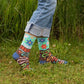 Blue Q 'I dig dirt' socks being worn by someone whilst they stand outside on the grass 