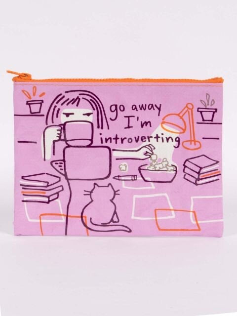 A purple Blue Q zipper pouch with a girl eating popcorn whilst drinking on. The text reads: ' Go away i'm introverting'