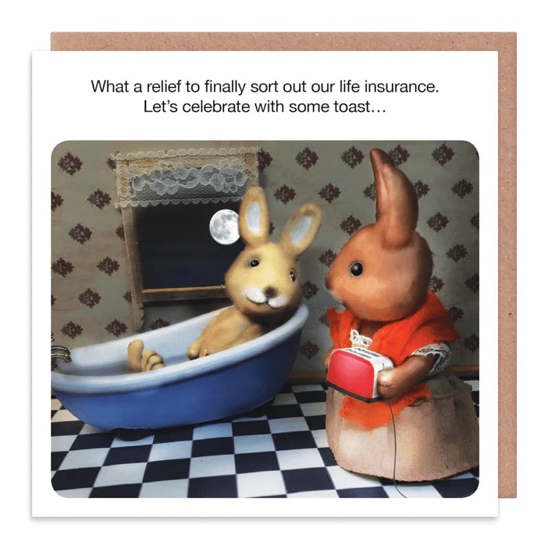 A white card with 2 rabbits on the front. One of them is in the bathtub and the other is stood at the side holding a toaster. The text on the card reads: What a relief to finally sort out our life in insurance. Lets celebrate with some toast....