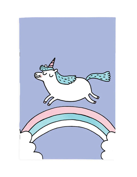 A purple notebook with the graphic of a cartoon unicorn jumping over a rainbow. 